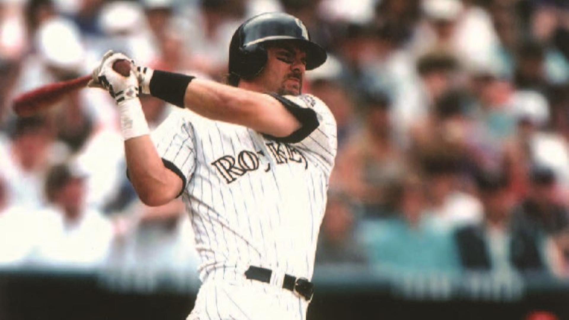 Larry Walker prepares to hit an incoming baseball with a bat.